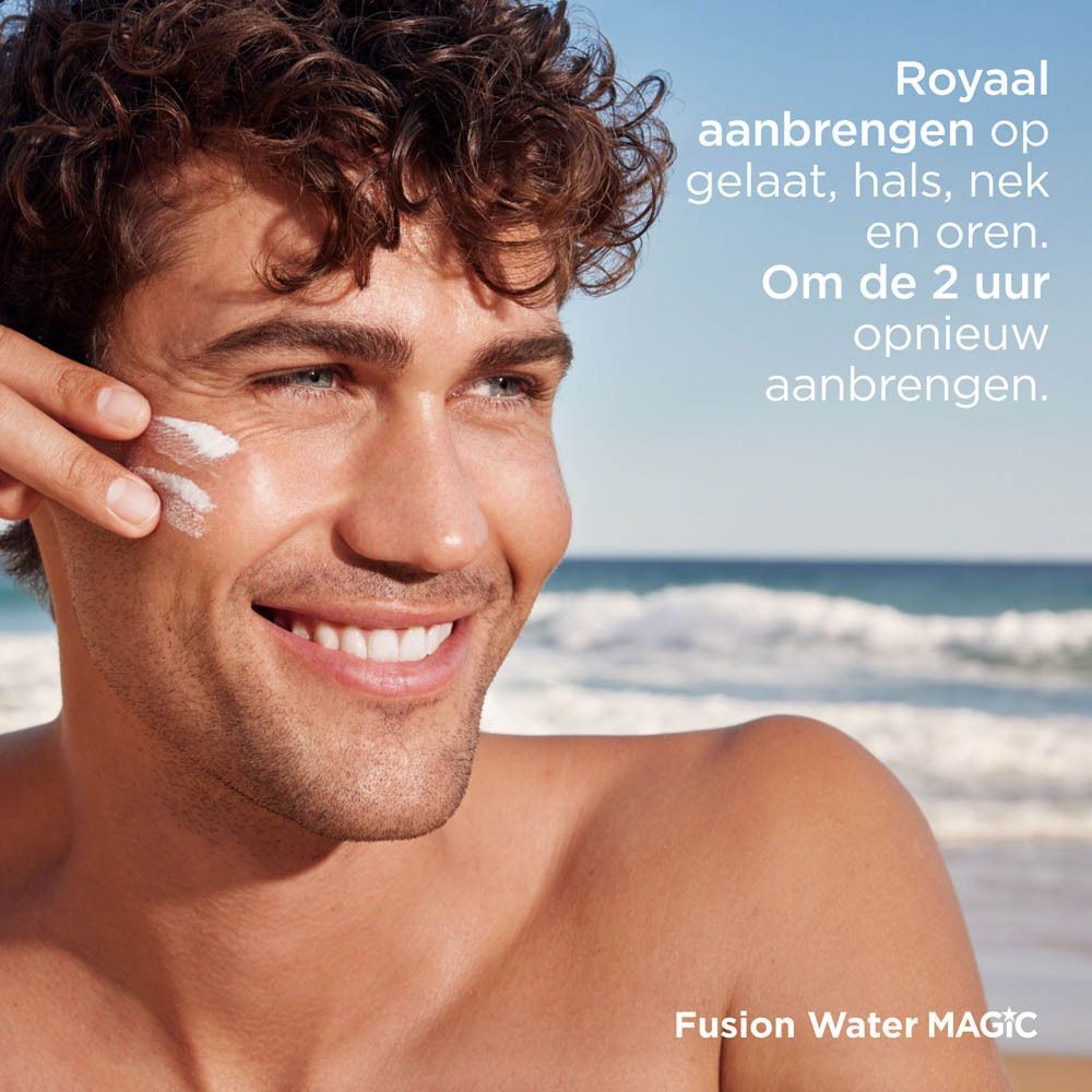 Man met zonnebrandcrème op gezicht op het strand.
