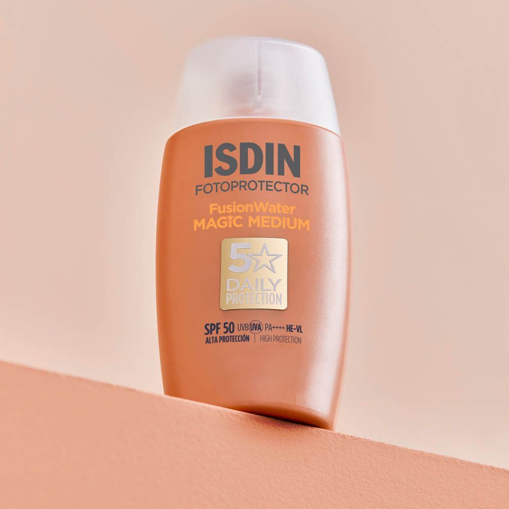 Bouteille de protection solaire ISDIN Fotoprotector Fusion Water Magic Medium sur fond rose.
