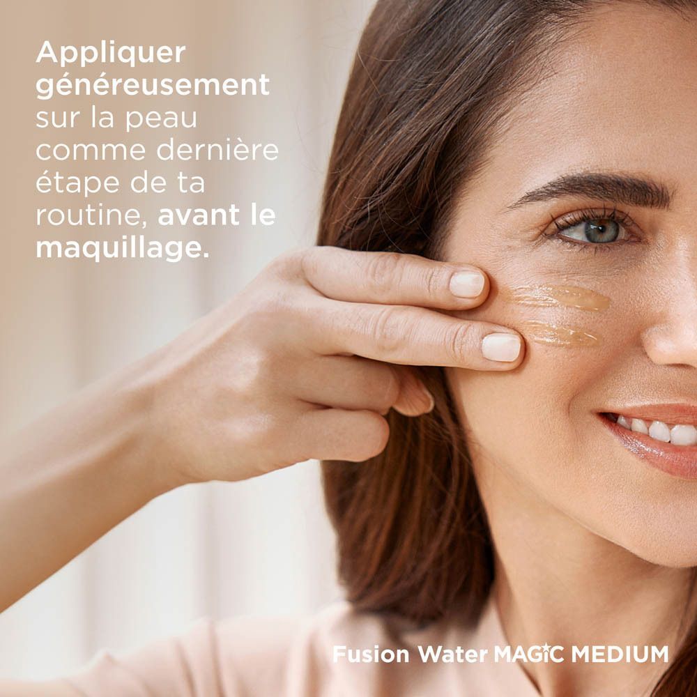 Une femme applique la crème solaire ISDIN Fusion Water sur sa joue.