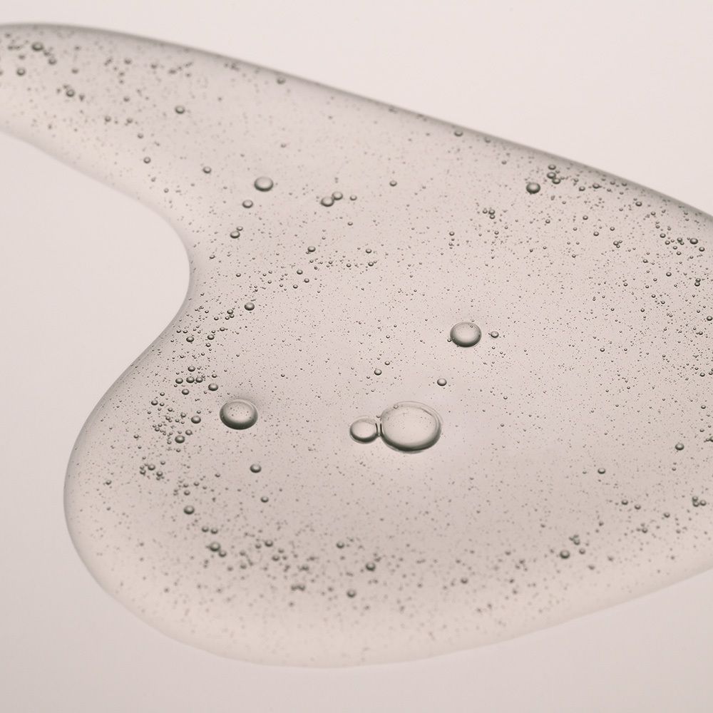 Liquide clair sur une coupelle en verre. Bulles visibles.