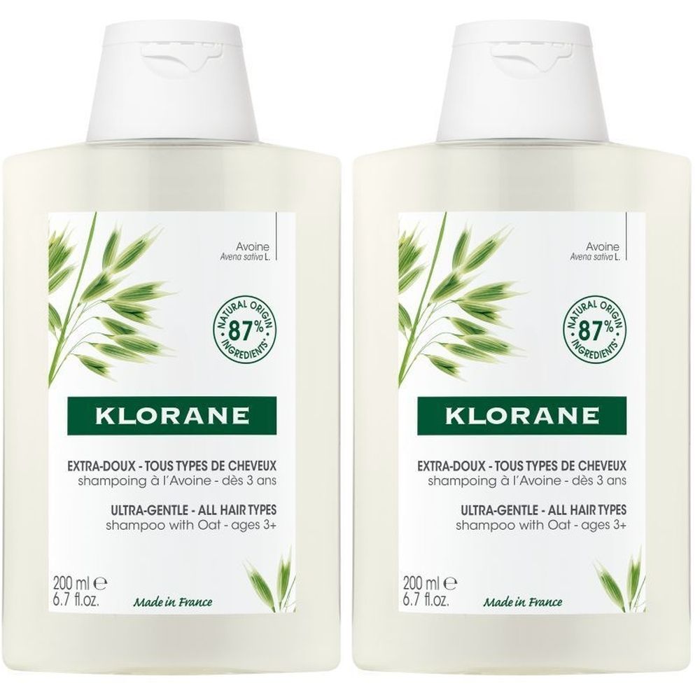 Deux flacons de shampooing Klorane. Bouteilles blanches avec étiquettes. Inscription: Extra-Doux, 87% ingrédients naturels.