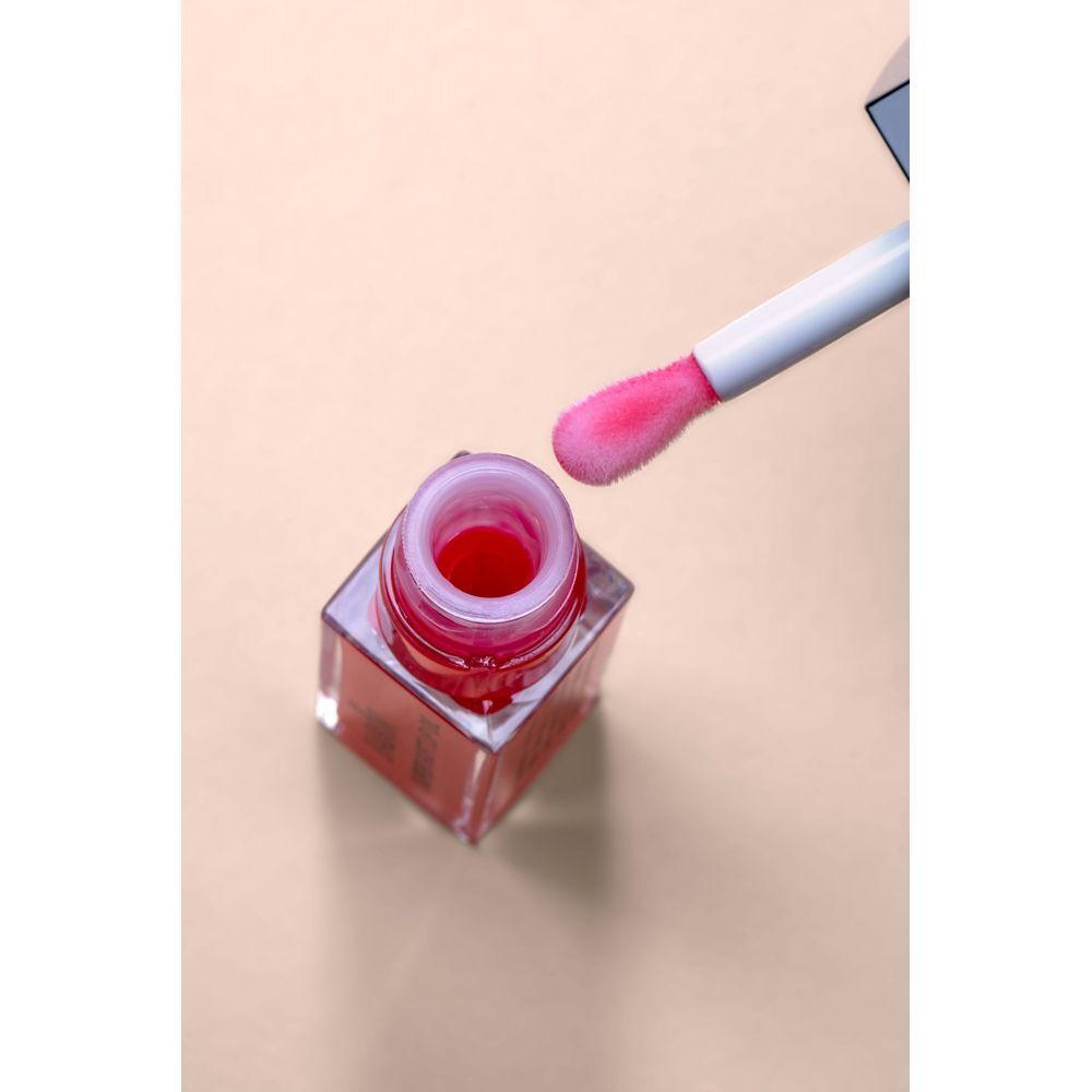 Open lipolie fles met applicator. Roze olie in de fles. Applicator met roze punt.