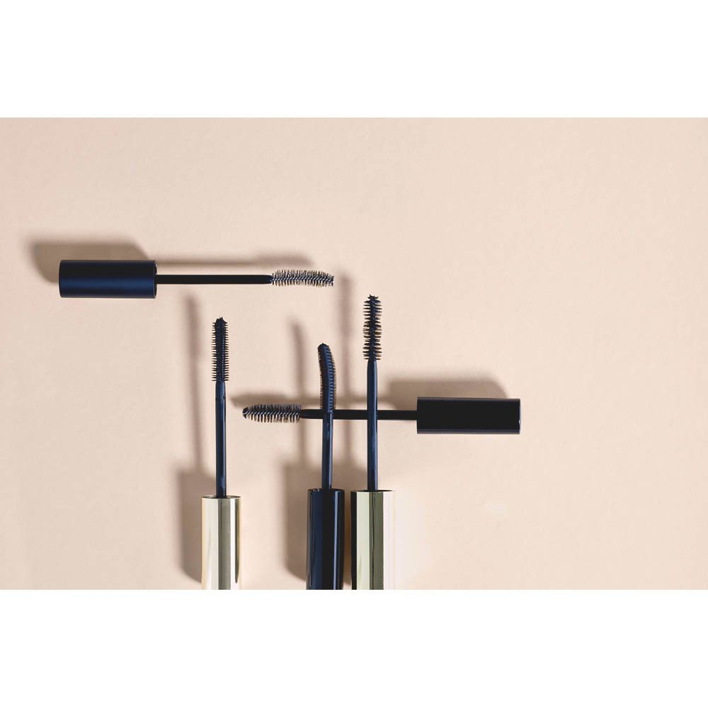 Plusieurs brosses de mascara de différents modèles. Accents dorés et bleus.