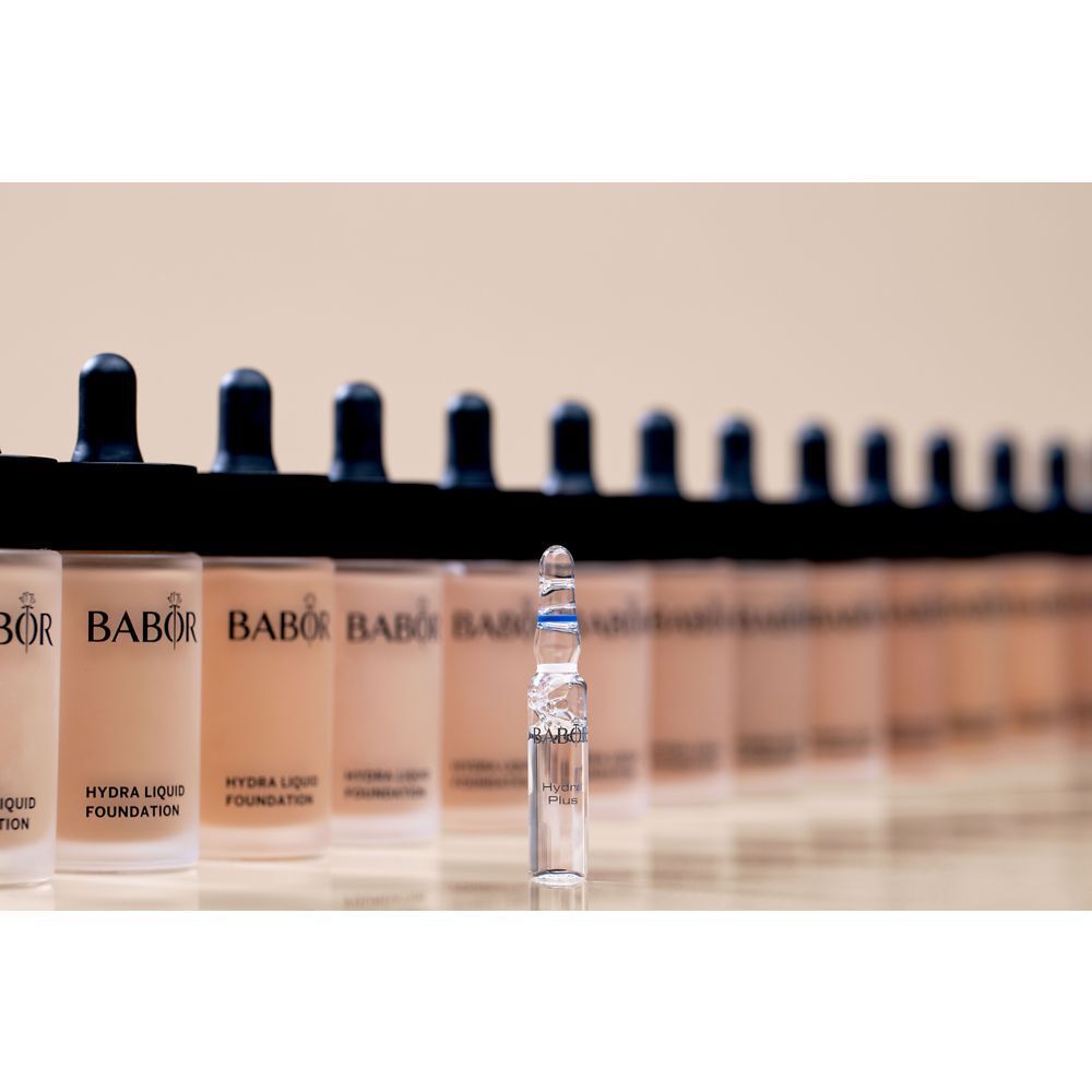 Rij foundationflessen met een ampul. Opschrift: Babor, Hydra Liquid Foundation.