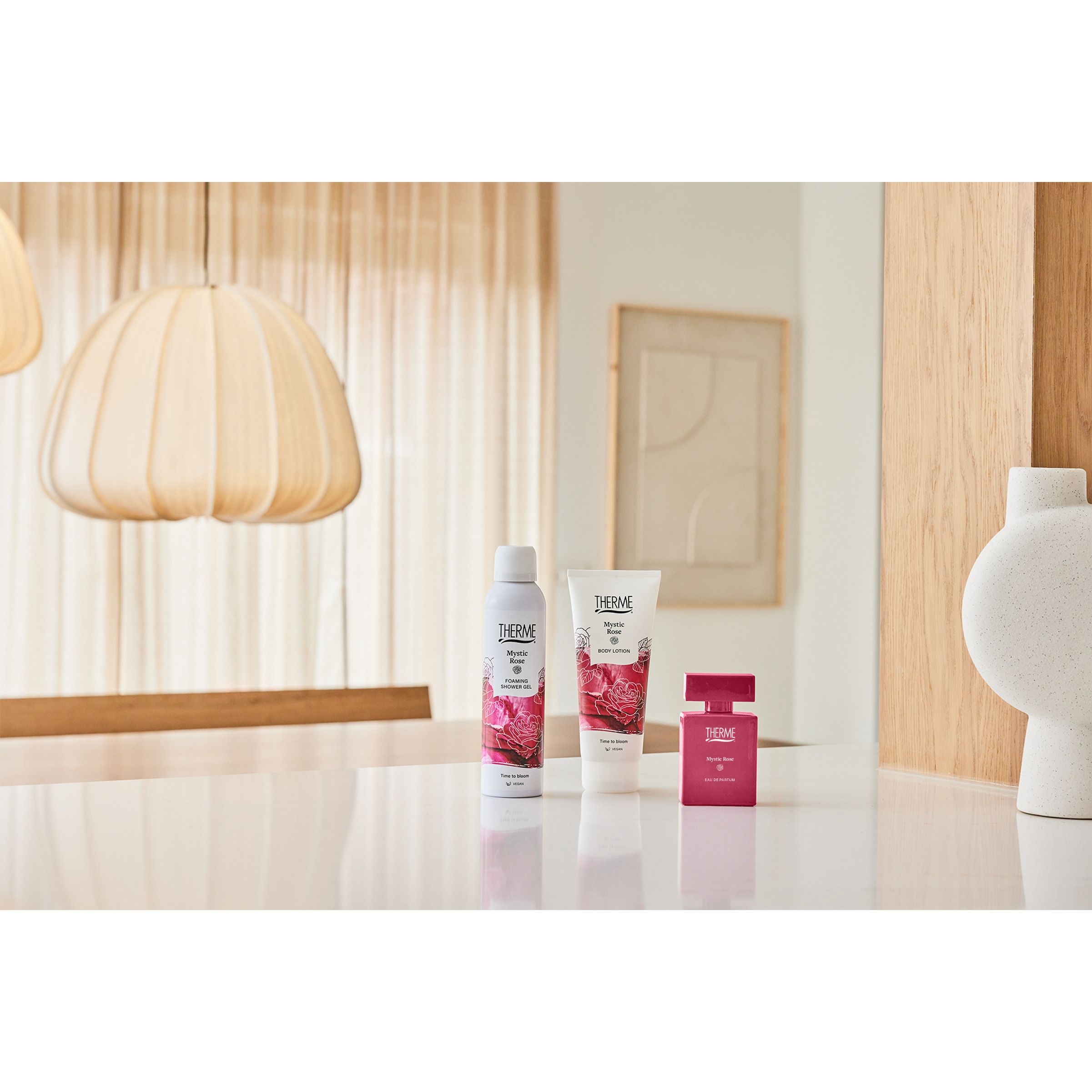 Productset van Therme Mystic Rose. Spray, crème, parfum. Geplaatst op een tafel.