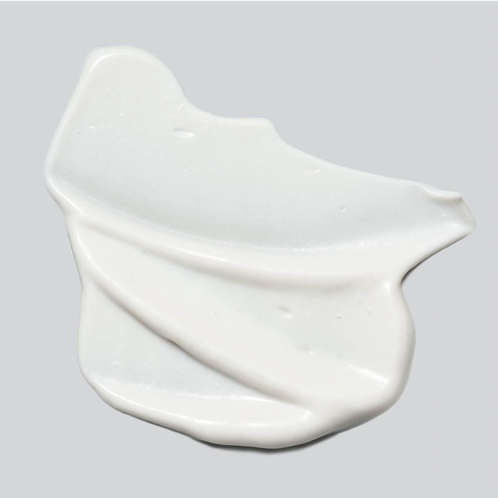 Produit crème blanc sur fond gris. Texture visible.