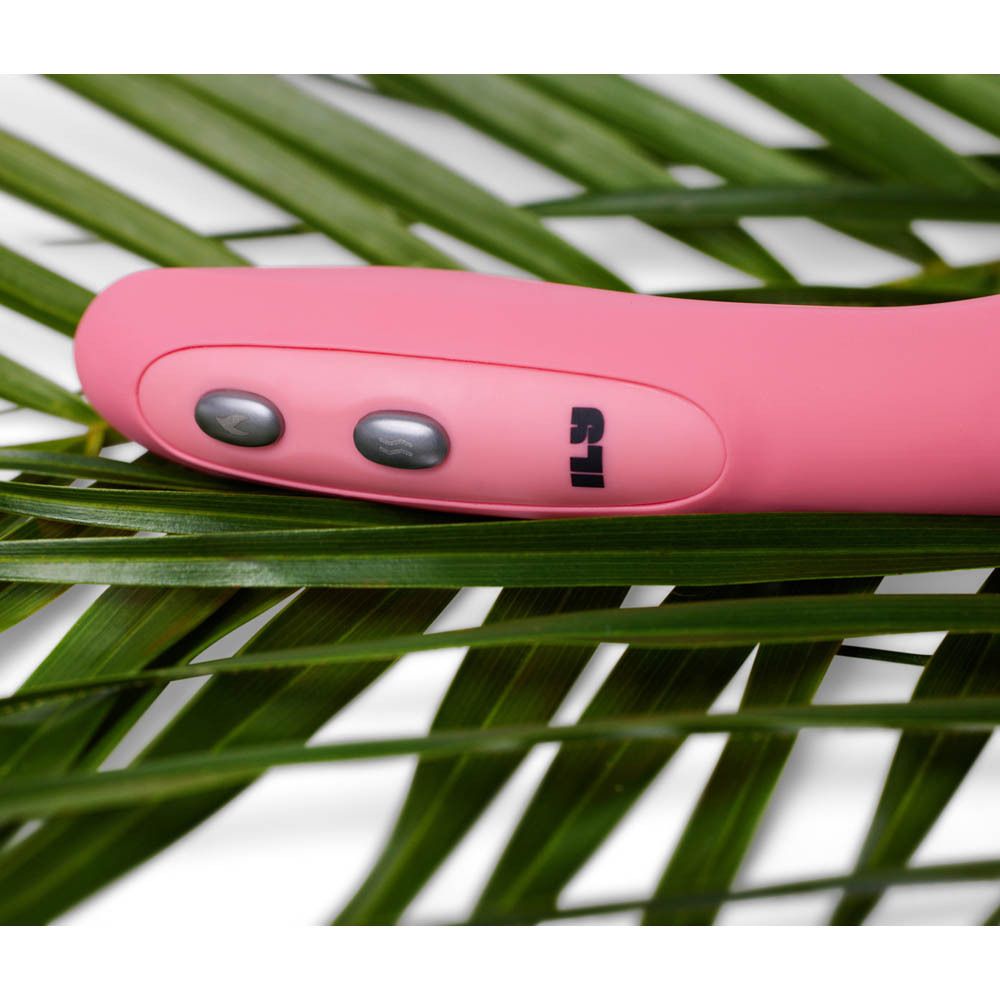 Roze vibrator met drie knoppen, op bladeren. Logo "ILS" zichtbaar.
