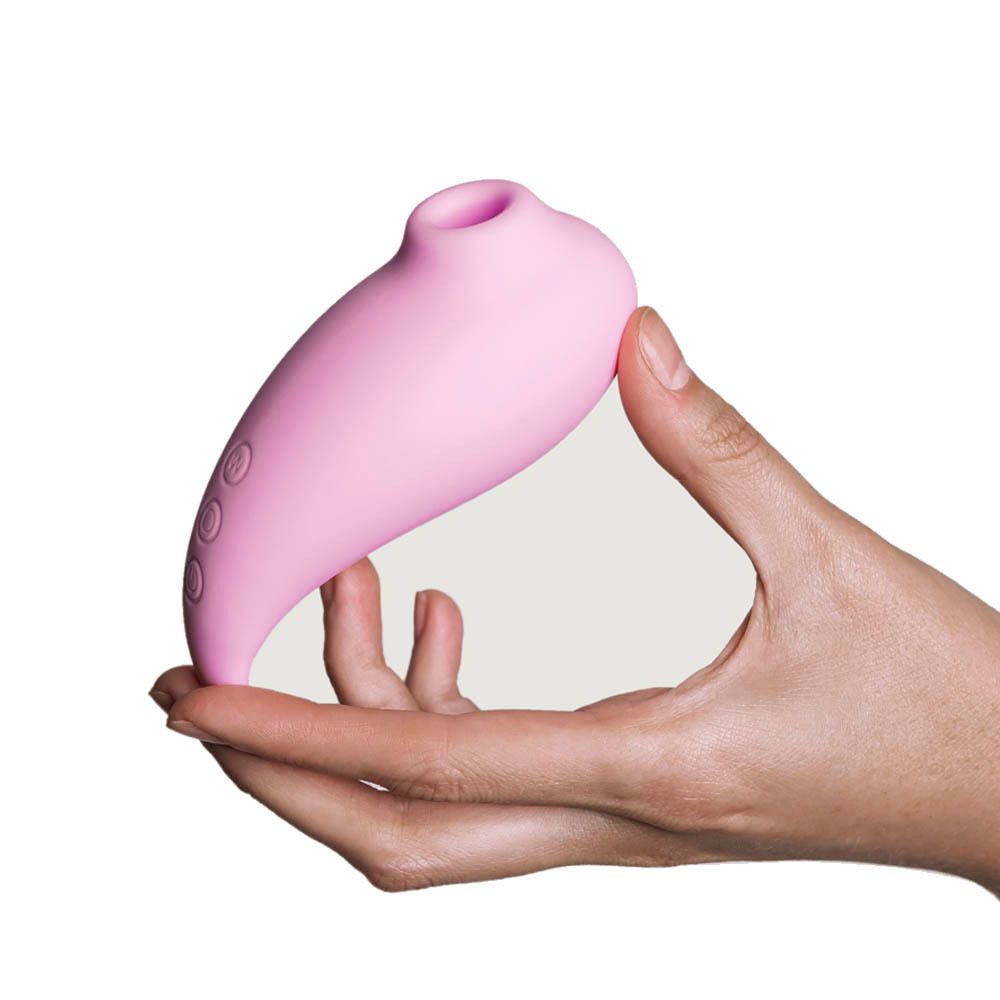 Stimulateur rose dans la main. Forme ovale, trois boutons. Pour la santé intime. Vue du produit.