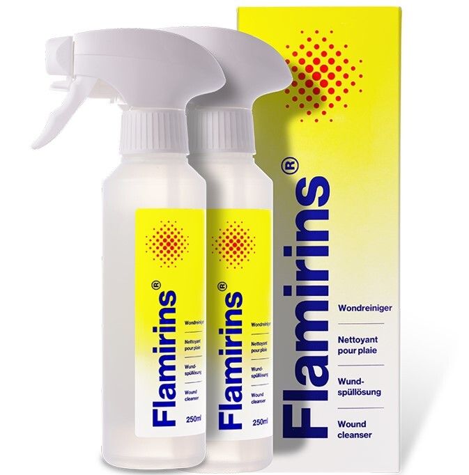 Twee flessen met verstuiver en geel etiket. Opschrift Flamirins, wondreiniger. Daarnaast een gele verpakking met rood puntpatroon.