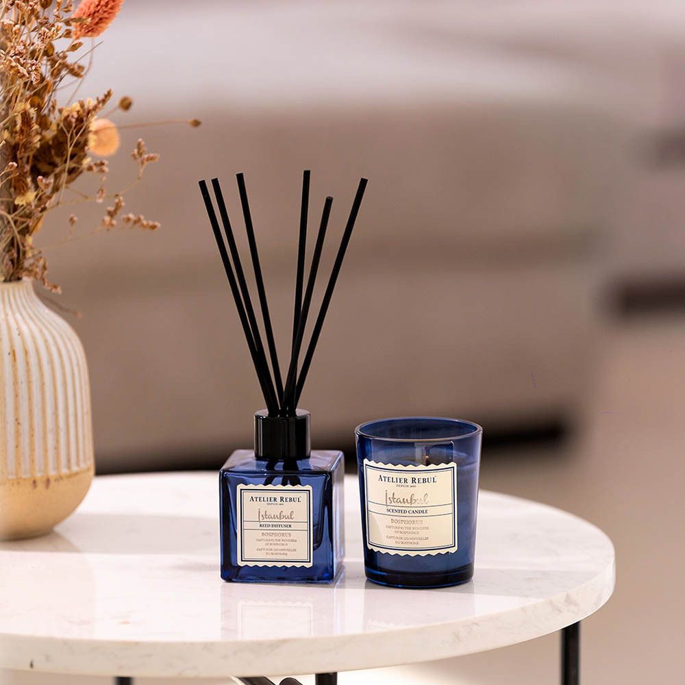 Productset: diffuser en kaars. Geplaatst op een tafel.