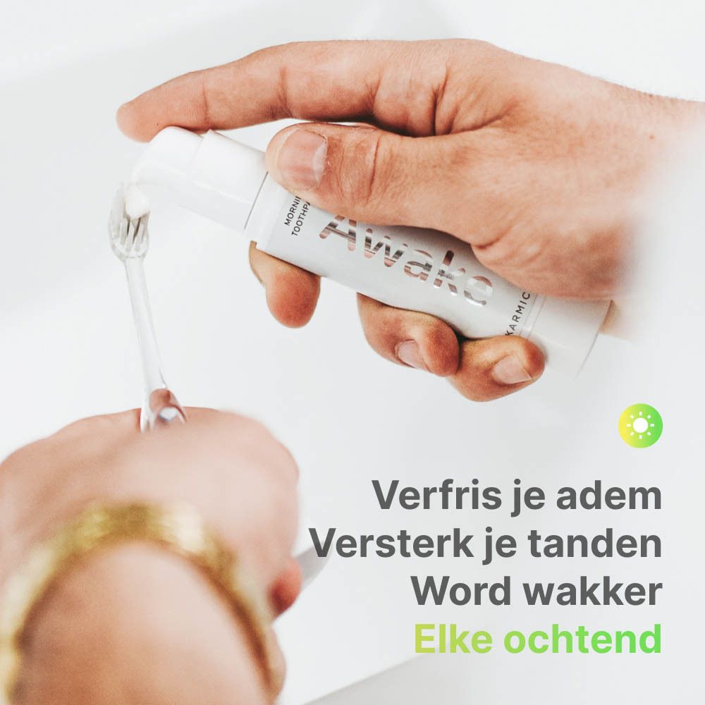 Persoon poetst tanden met witte tandpasta. Opschrift: Awake. Merk: Karmicare. Nederlandse tekst.