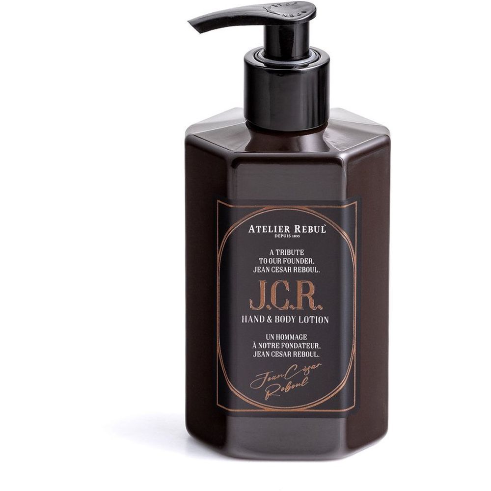 Bruine fles met doseerpomp. Opschrift: Atelier Rebul J.C.R. Hand & Body Lotion. Gouden tekst.