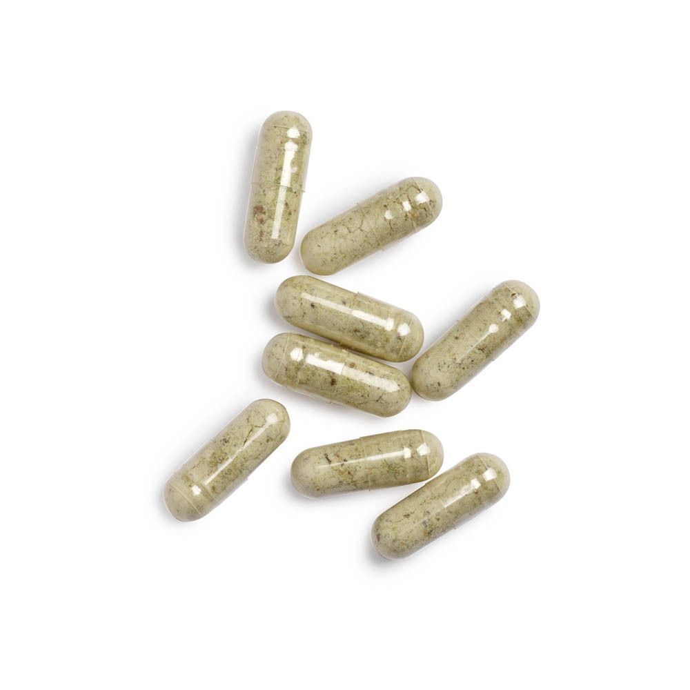 Zeven doorzichtige capsules met groenige inhoud op een witte achtergrond.