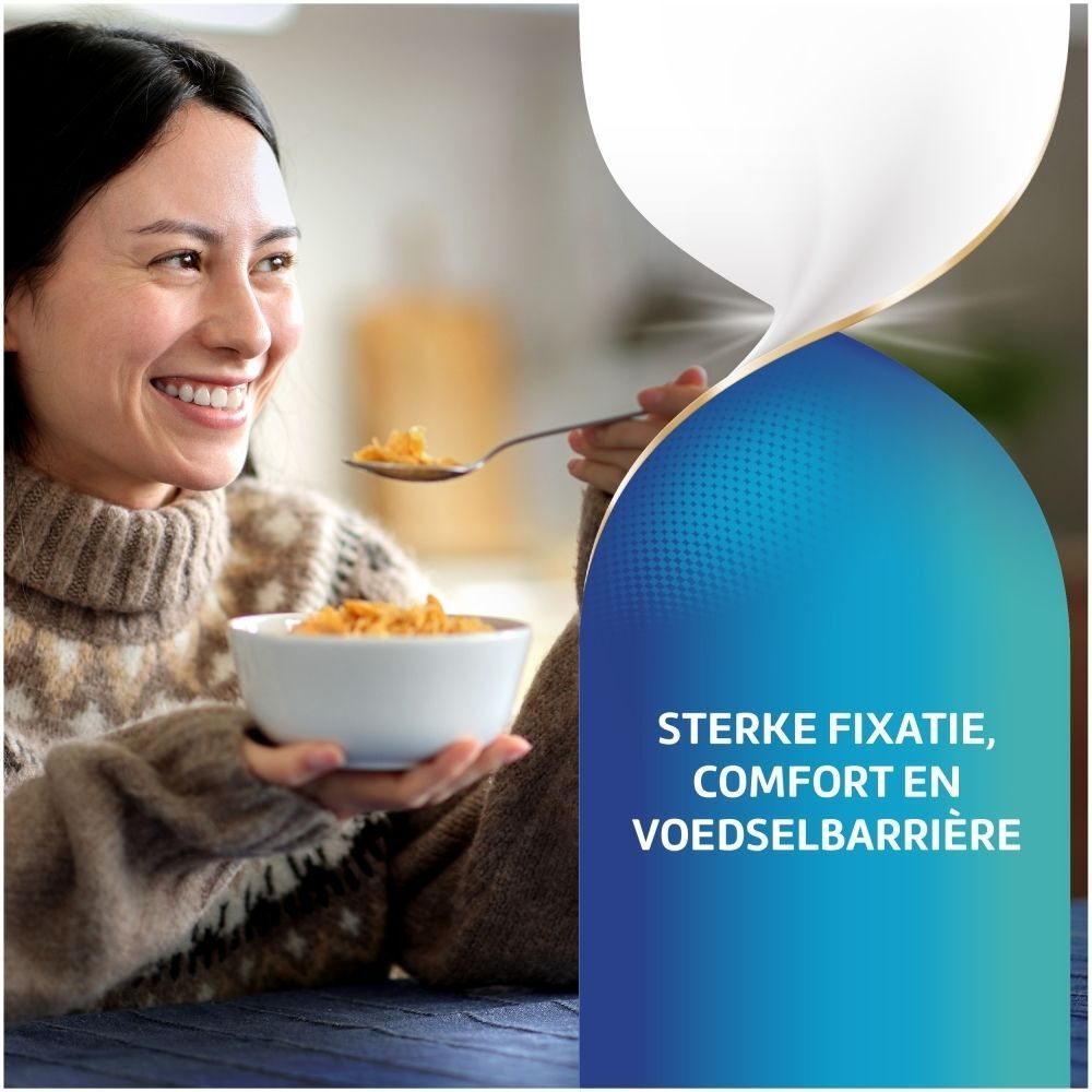 Vrouw eet ontbijt. De crème zorgt voor sterke fixatie, comfort en voedselbarrière.