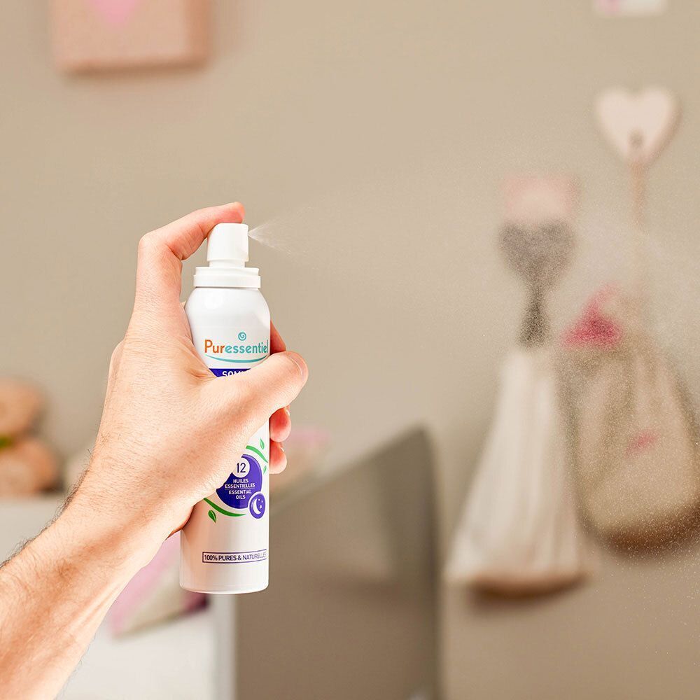 Hand spuit Puressentiel luchtspray in een kamer. Nevel is zichtbaar.