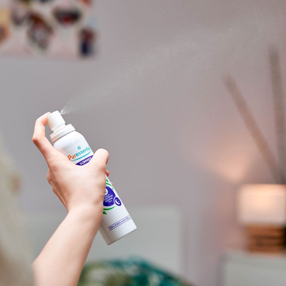 Hand spuit Puressentiel luchtspray in een kamer. Nevel is zichtbaar.