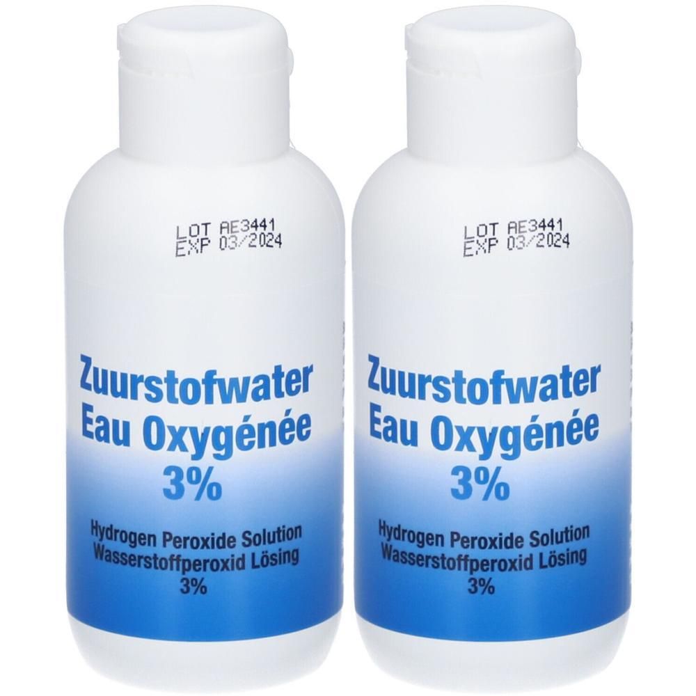 Twee witte flessen met blauw etiket. Opschrift: Eau Oxygénée 3%. Houdbaarheidsdatum 03/2024.