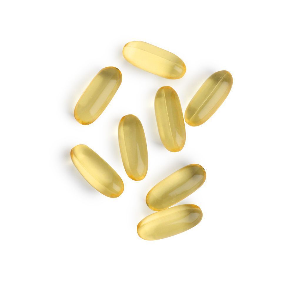 Acht gele, ovale capsules op een witte achtergrond.