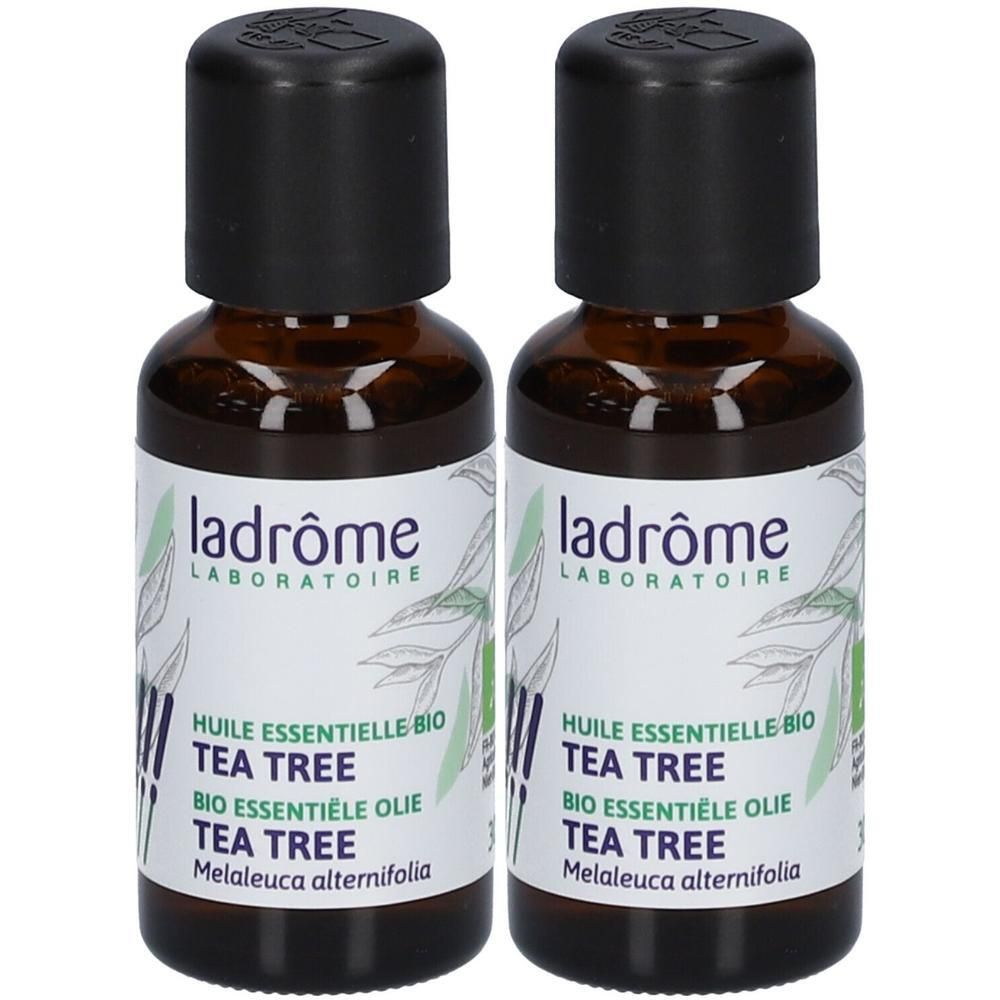 Twee bruine glazen flessen met zwarte dop. Etiket met tekst: Ladrôme, Tea Tree Bio, essentiële olie.