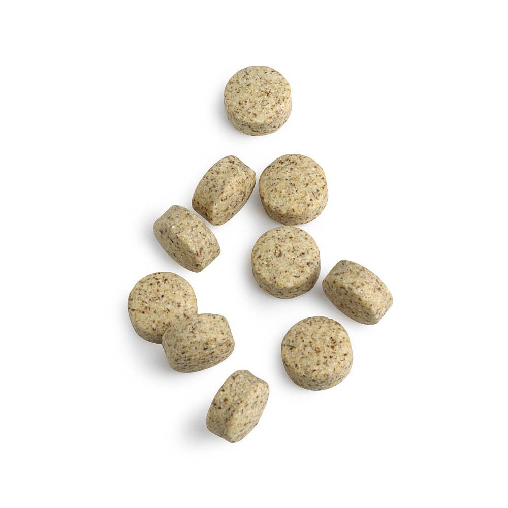 Meerdere ronde en ovale tabletten met zichtbare deeltjes op witte achtergrond.