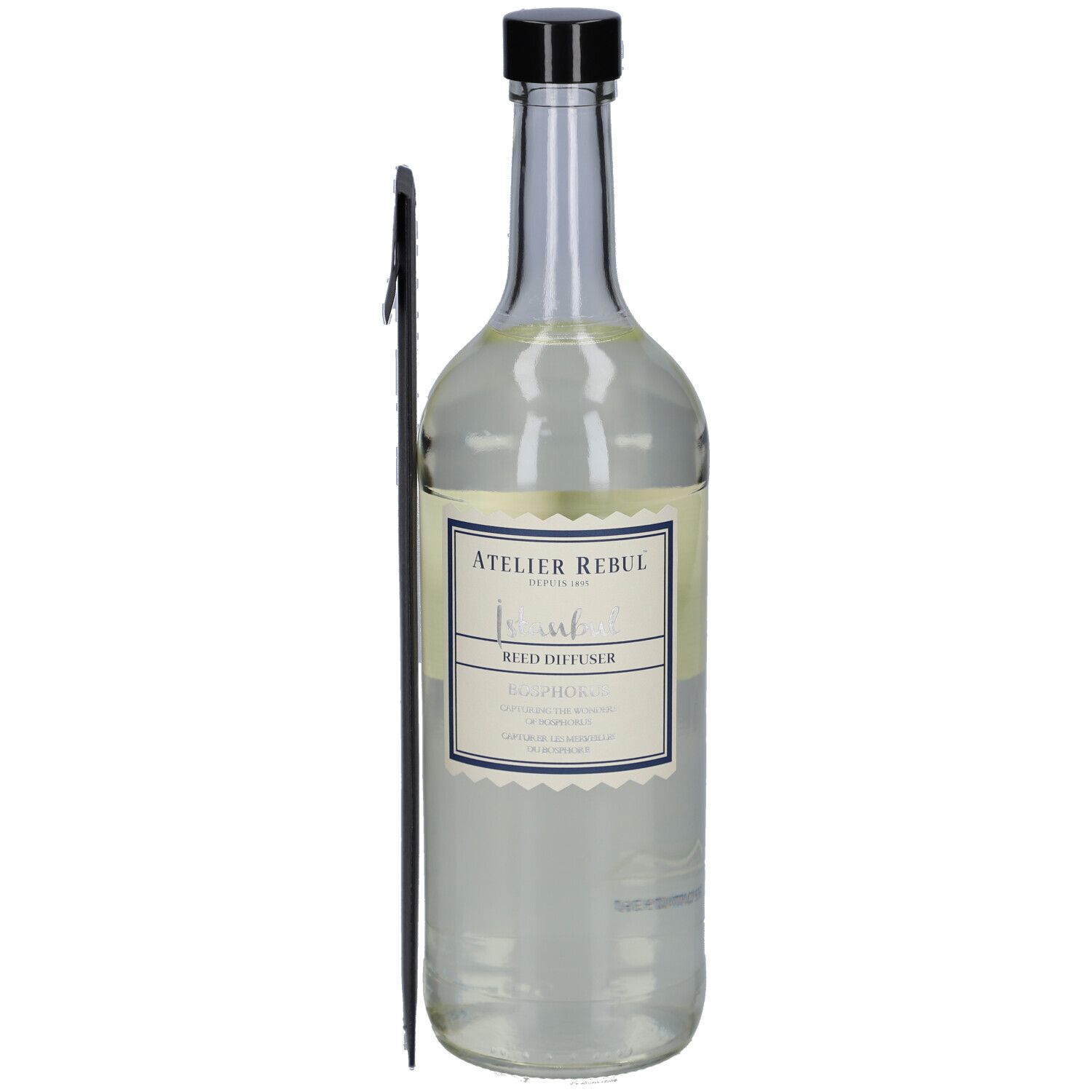 Glazen fles met zwarte dop, etiket en zwarte diffuser-staaf. Opschrift: Atelier Rebul, Istanbul Bosphorus.