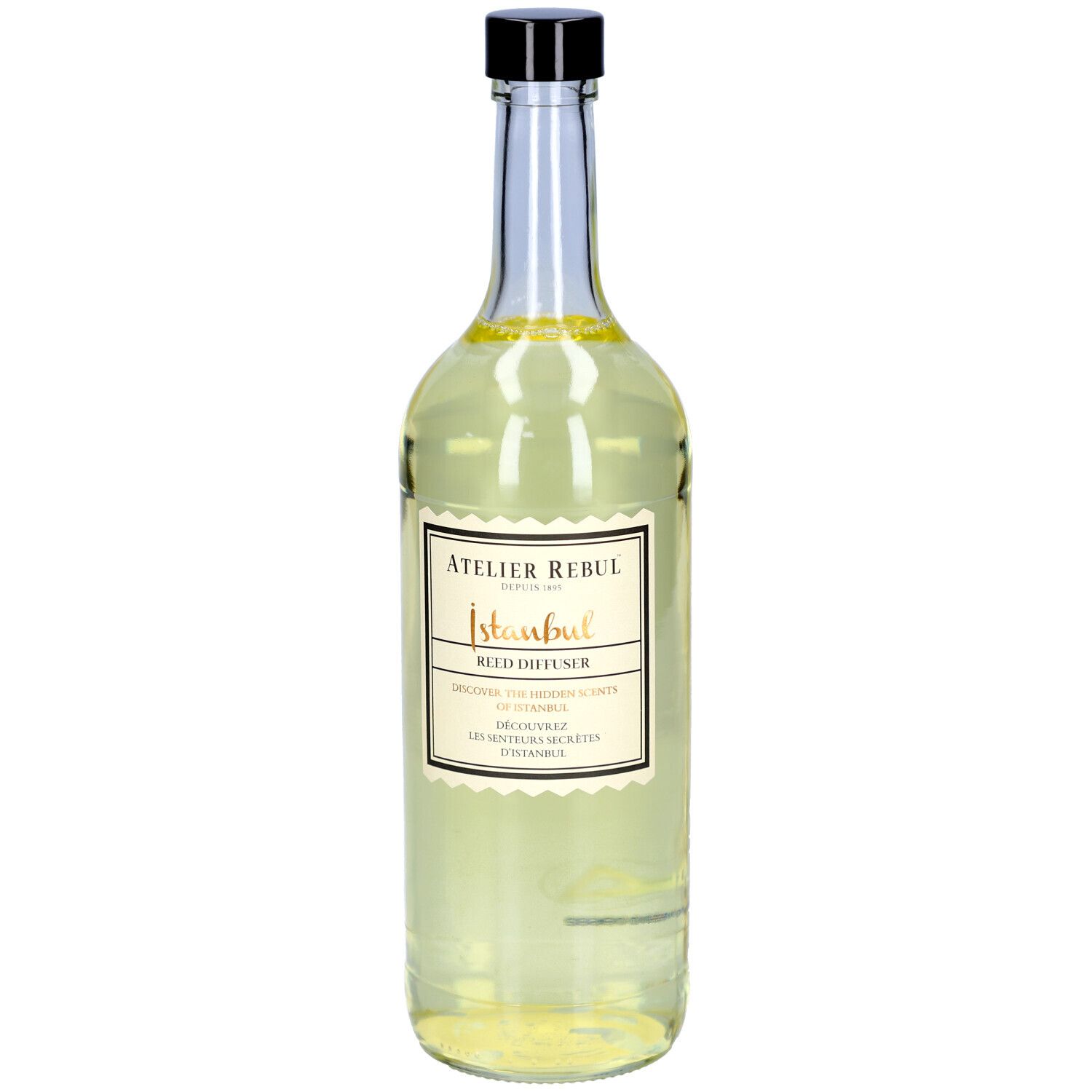 Glazen fles met zwarte dop en etiket. Opschrift: Atelier Rebul Istanbul Reed Diffuser.