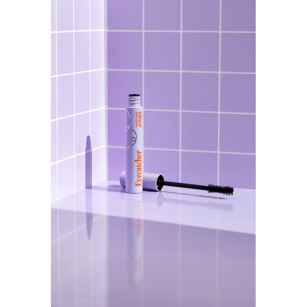 Mascara tube en borstel in lila omgeving. Lila tube met oranje tekst 'Eyecatcher'.