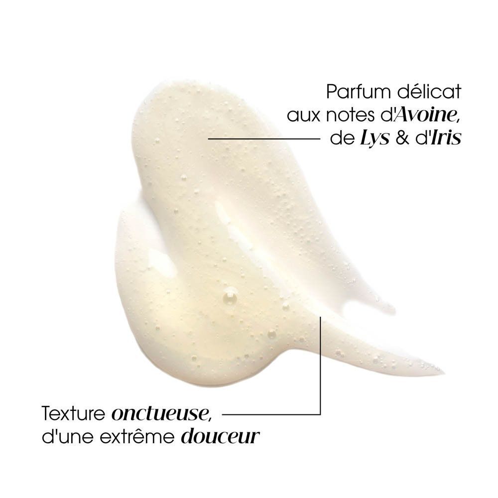 Gros plan sur la texture du shampooing. Jaune clair. Texte : Parfum délicat aux notes d'Avoine, de Lys & d'Iris. Texture onctueuse.