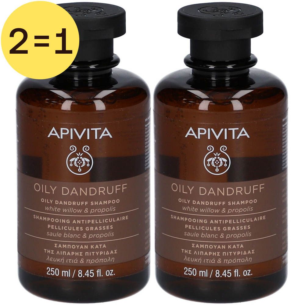 Deux flacons marron de shampooing Apivita Oily Dandruff. Inscription : Oily Dandruff Shampoo, saule blanc & propolis. Cercle jaune avec "2=1".