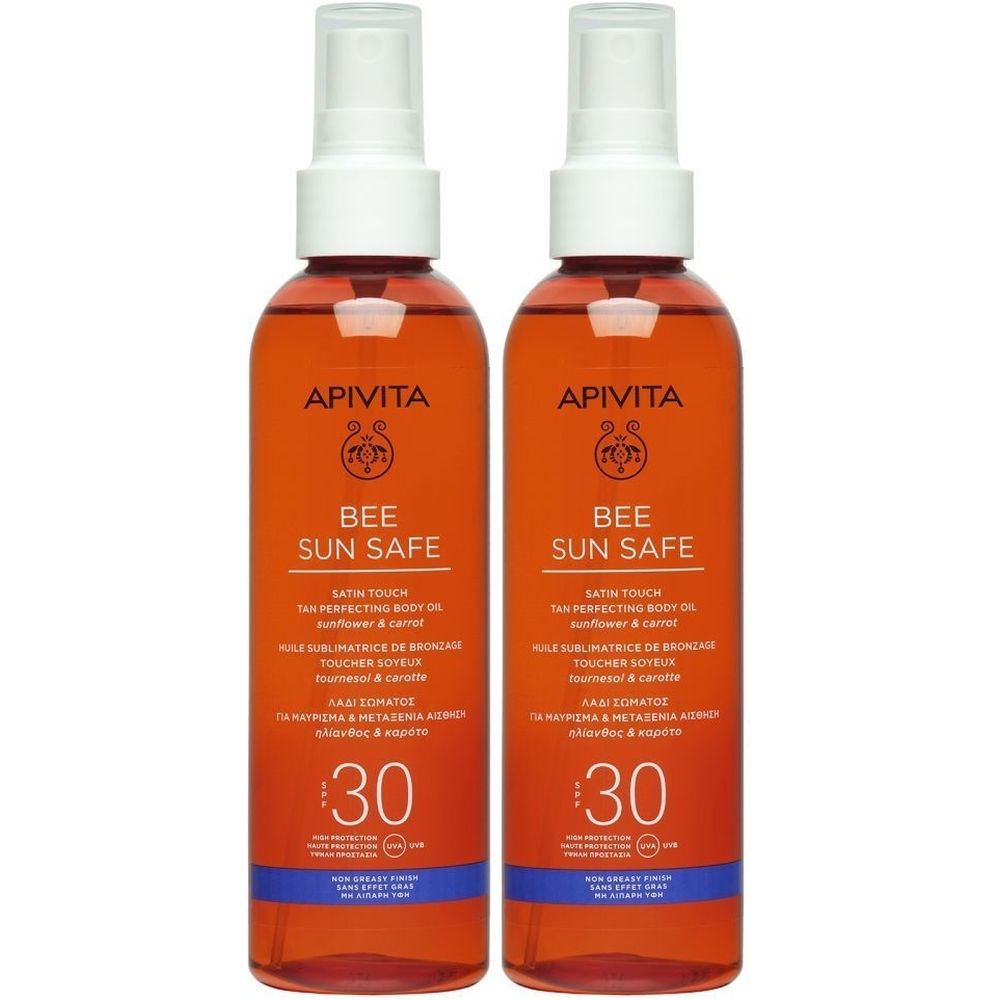Twee oranje spuitflessen. Opschrift: Apivita Bee Sun Safe SPF30. Witte spuitkoppen.