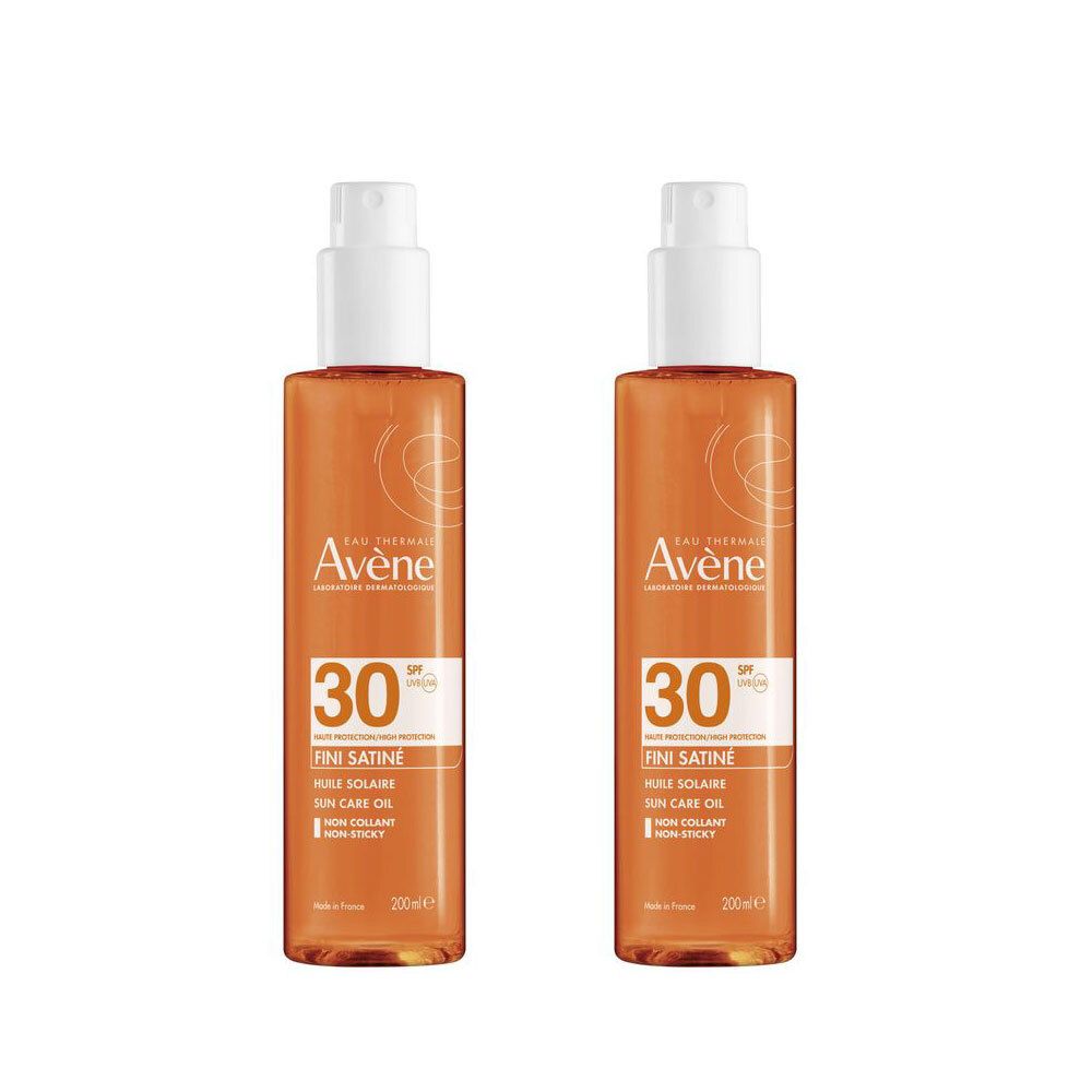 Deux flacons de spray d'huile solaire. Inscription Avène, SPF 30, Fini Satiné. Liquide orangé, tête de pulvérisation blanche.