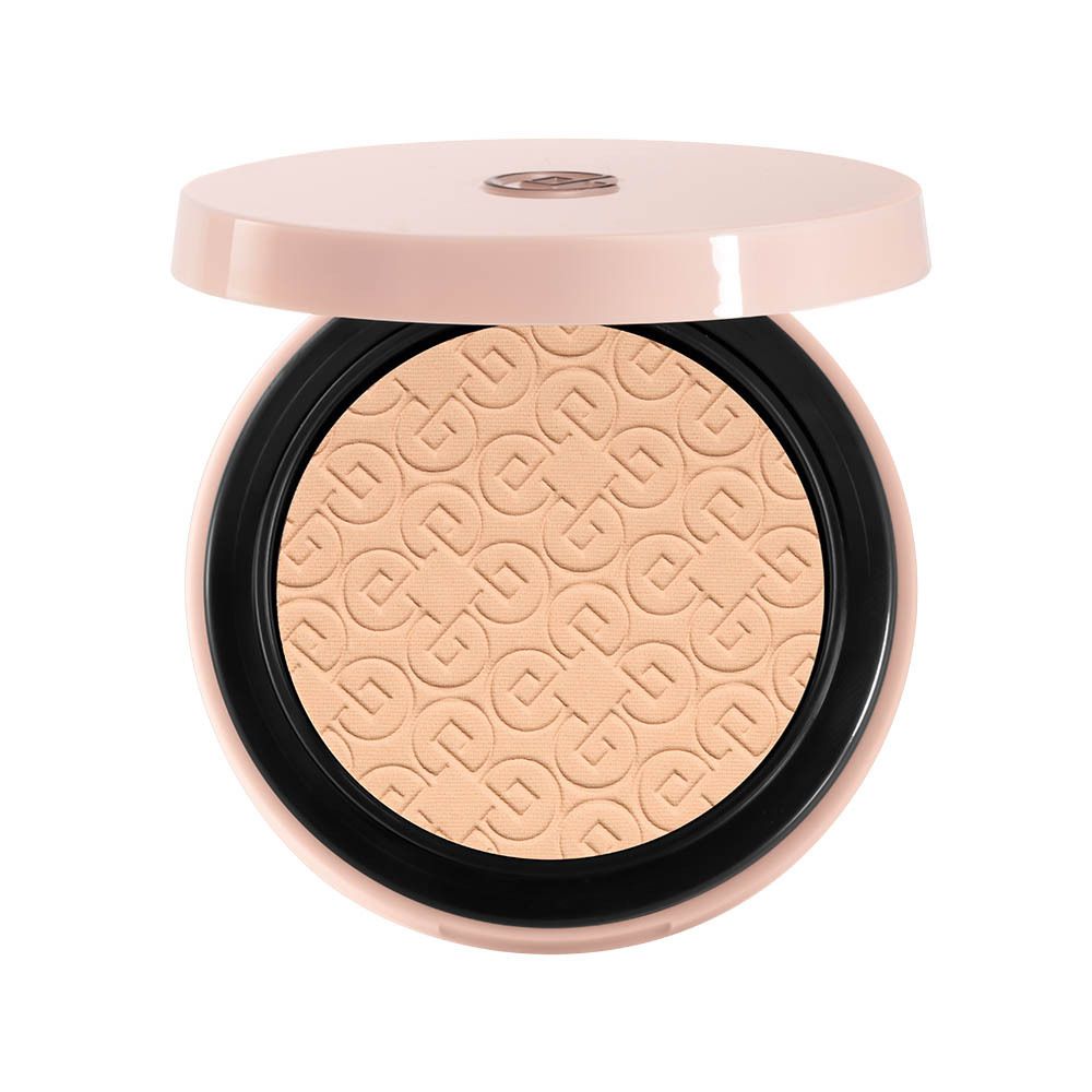 Poudre compacte ouverte. Poudre beige avec motif en relief. Couvercle rose et bord noir.