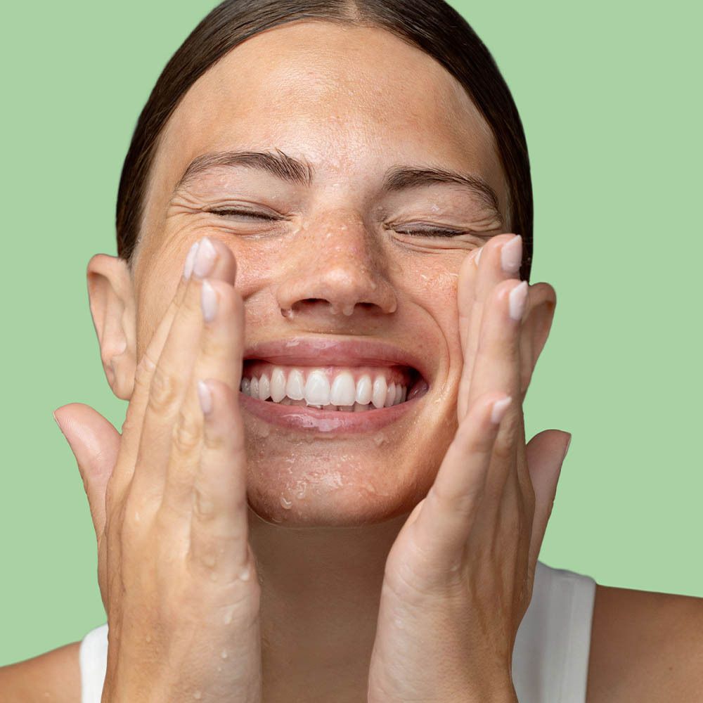 Gros plan d'un visage avec de la mousse. La personne a les yeux fermés. Produit : Cleansing Cream To Mousse.