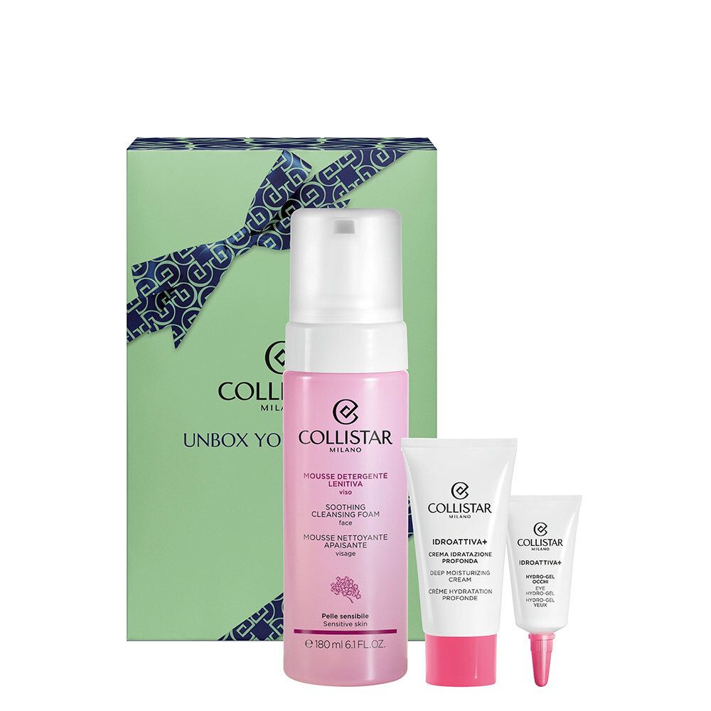 Cadeauset met drie cosmetische producten. Groene doos met strik, roze fles en twee witte tubes.