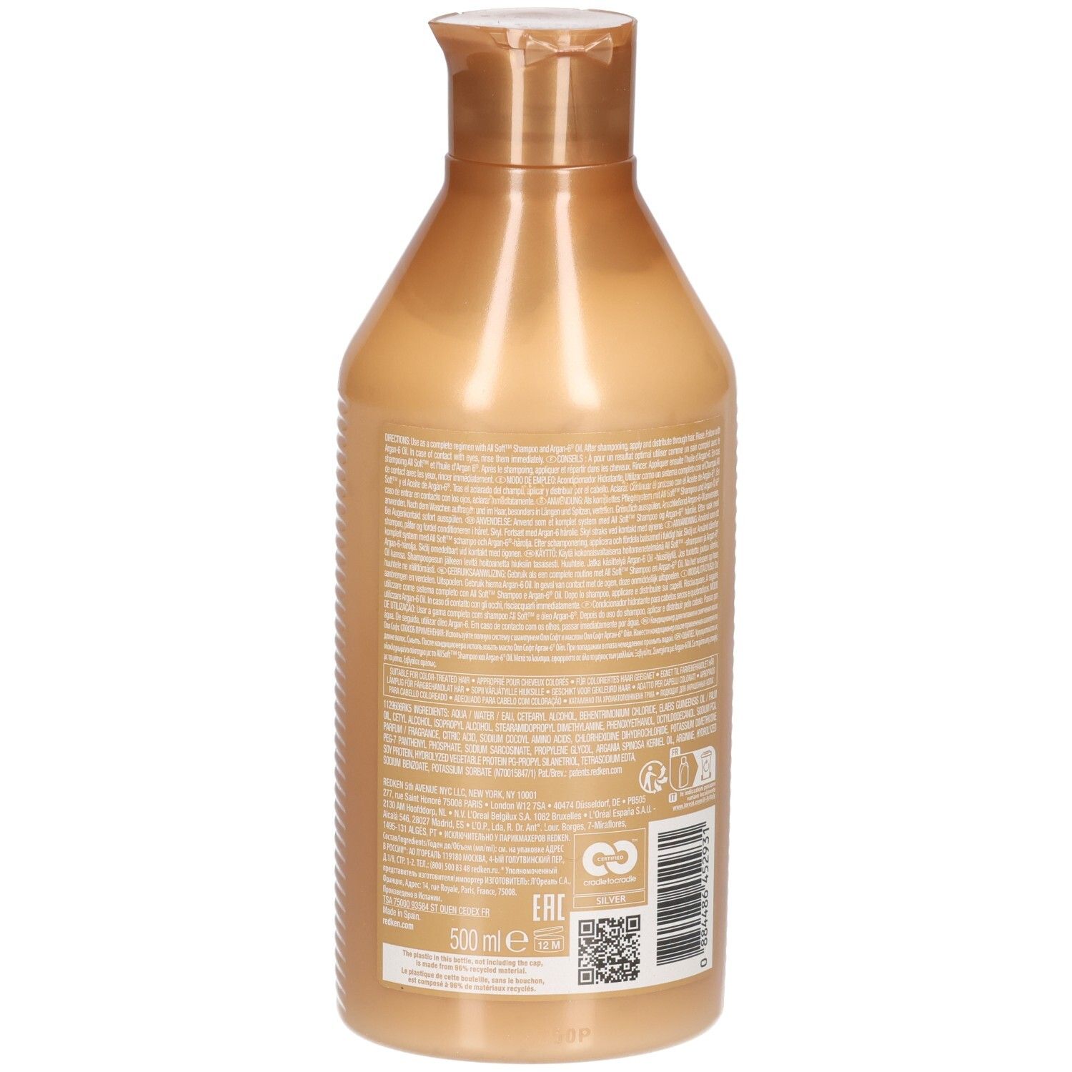 Achterkant van een gouden conditionerfles. Tekst op het etiket.