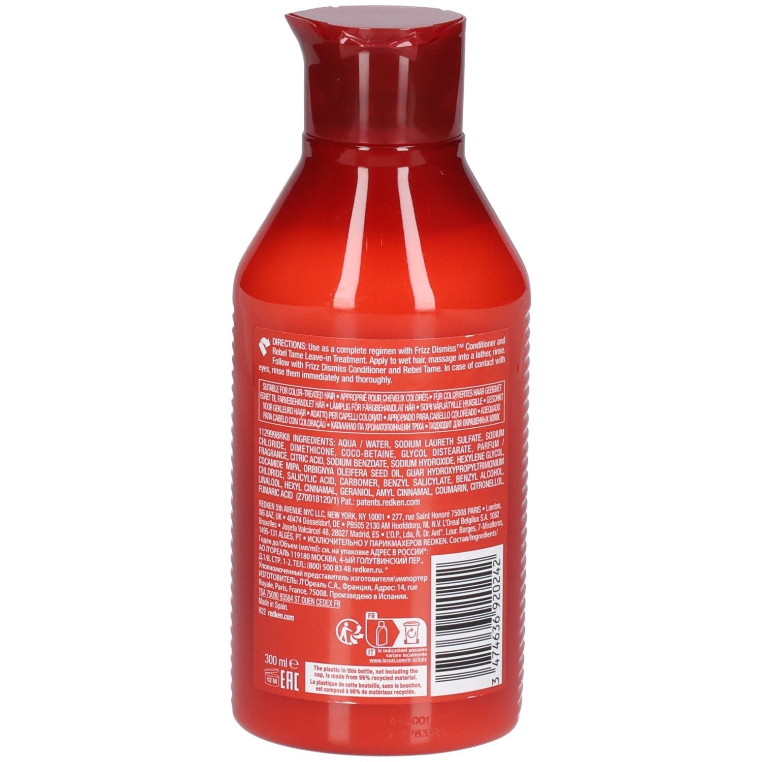 Achterkant van een rode shampoo fles. Bevat tekst over ingrediënten en gebruik. Streepjescode en logo.