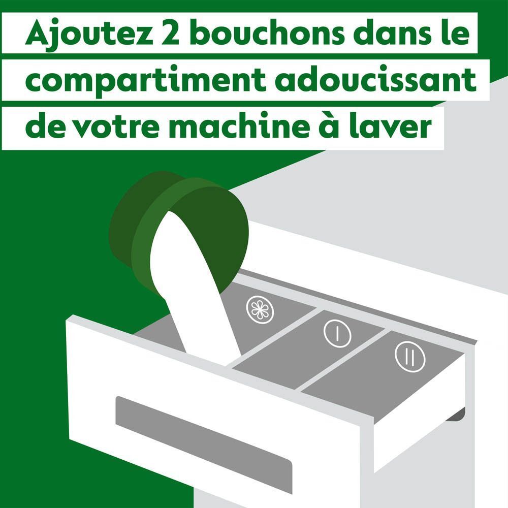 Un bouchon vert est versé dans le compartiment d'une machine à laver.