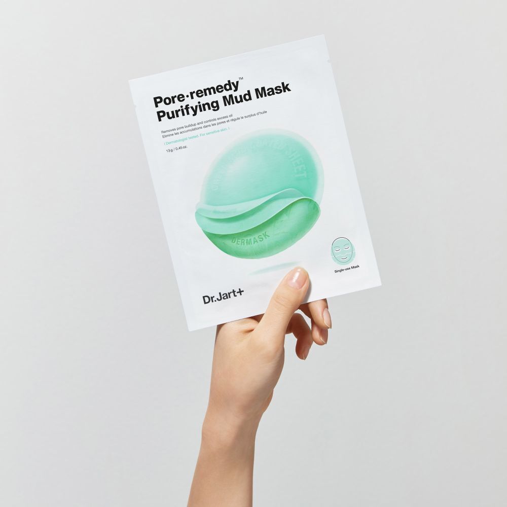 Main tenant un paquet de masque. Inscription : Pore·remedy Purifying Mud Mask. Marque : Dr.Jart+.