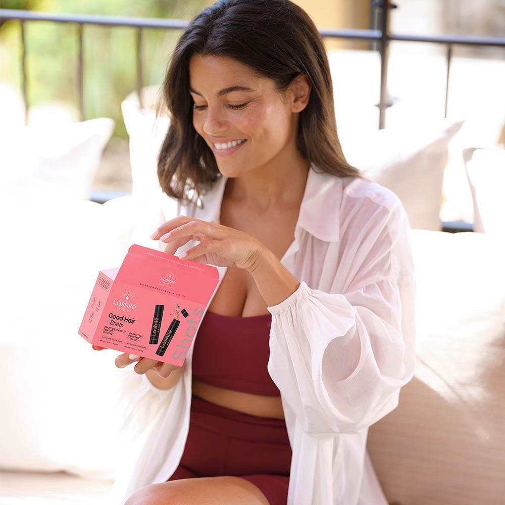 Zwarte fles Lashilé Beauty. Tekst: Good Hair Shots. Ingrediënten: venushaar, selenium, heermoes.