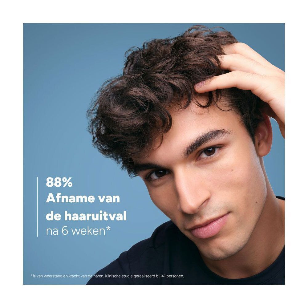 Man met donker haar die aan zijn hoofd krabt. Tekst: 88% minder haaruitval na 6 weken.
