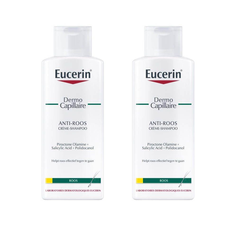 Twee witte flessen Eucerin DermoCapillaire Anti-Roos Crème-Shampoo. Rode tekst Eucerin, groene streep, productnaam.