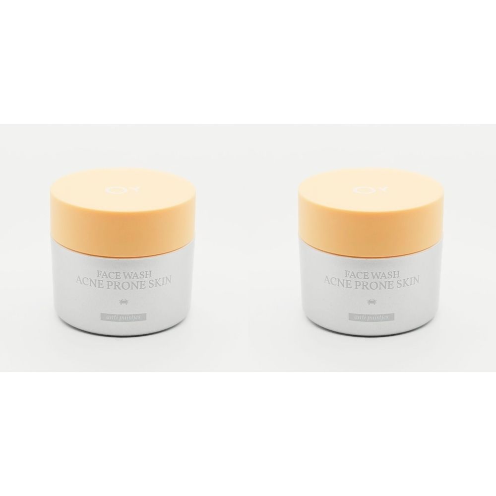Twee grijze ronde potten met oranje deksels. Opschrift: FACE WASH ACNE PRONE SKIN.