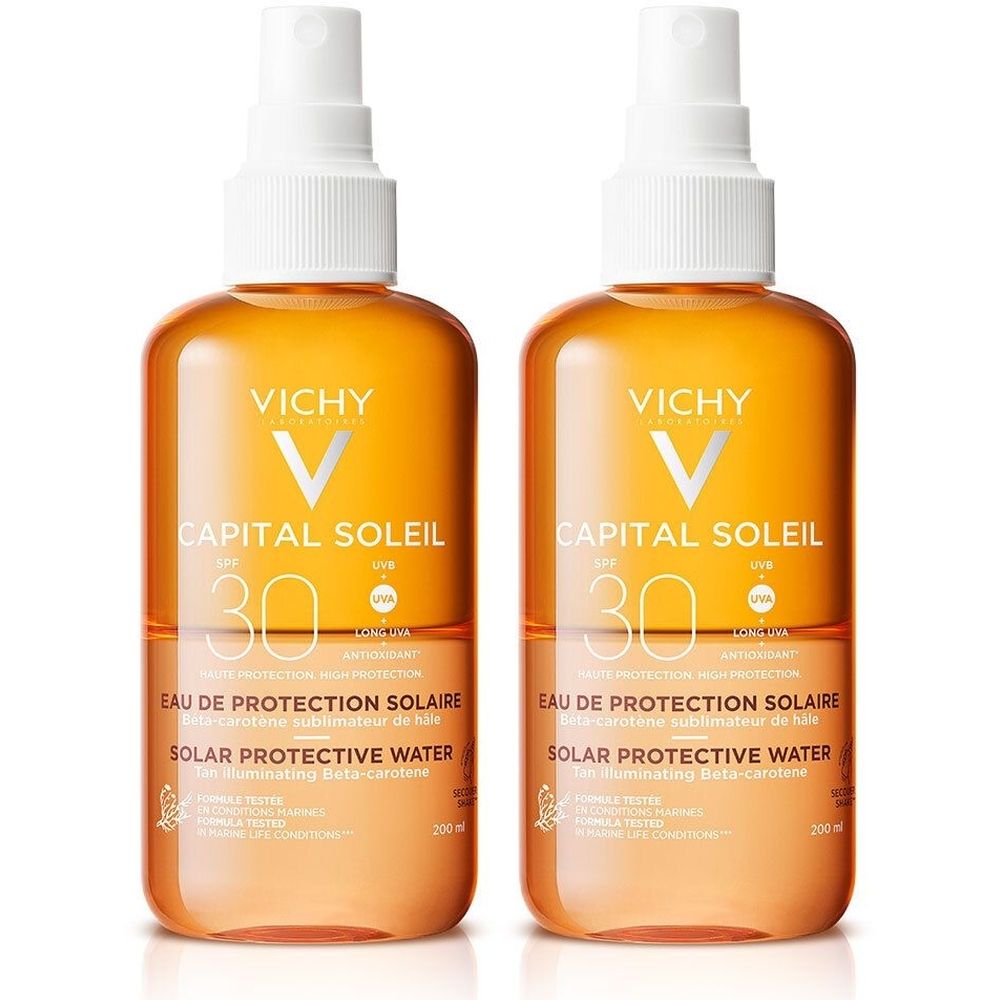 Deux flacons de VICHY Capital Soleil Eau protectrice solaire LSF 30. Liquide orangé, vaporisateur blanc. Texte: Capital Soleil, LSF 30, Eau de Protection Solaire.