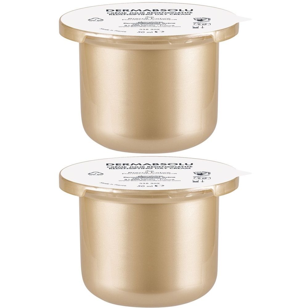 Twee goudkleurige crèmetiegels met witte deksels. Opschrift "Dermabsolu".