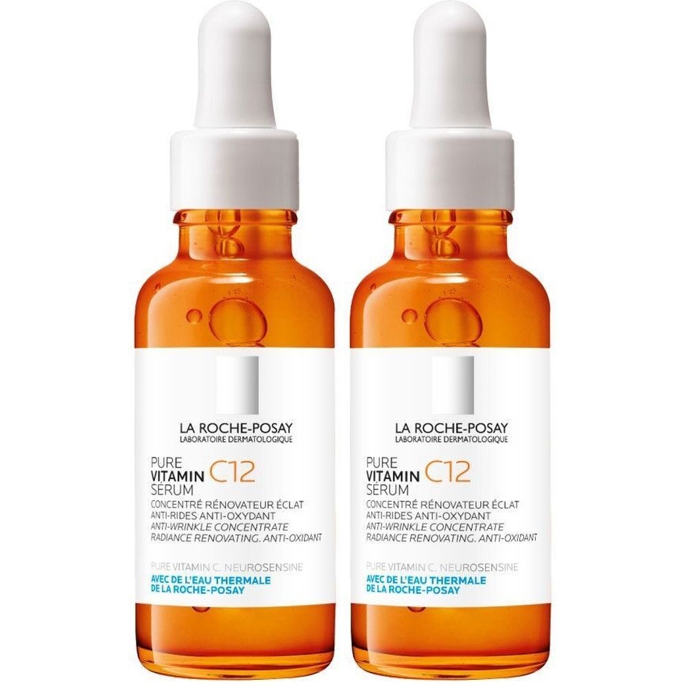 Twee serumflessen. Oranje glas met wit etiket. Opschrift: Pure Vitamin C12 Serum. Met pipet.