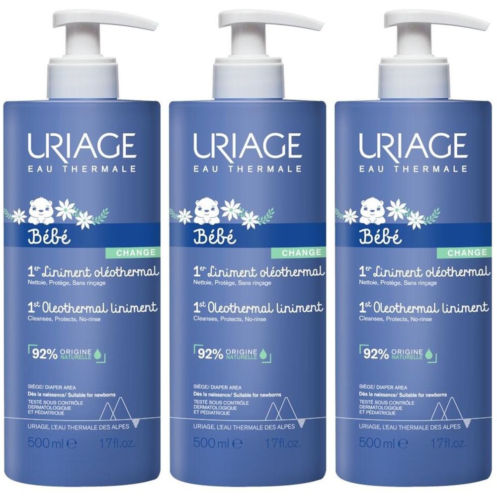 Drie blauwe flessen met witte pomp. Opschrift: Uriage Bébé, 1er Liniment oléothermal. 92% natuurlijke oorsprong. 500 ml.