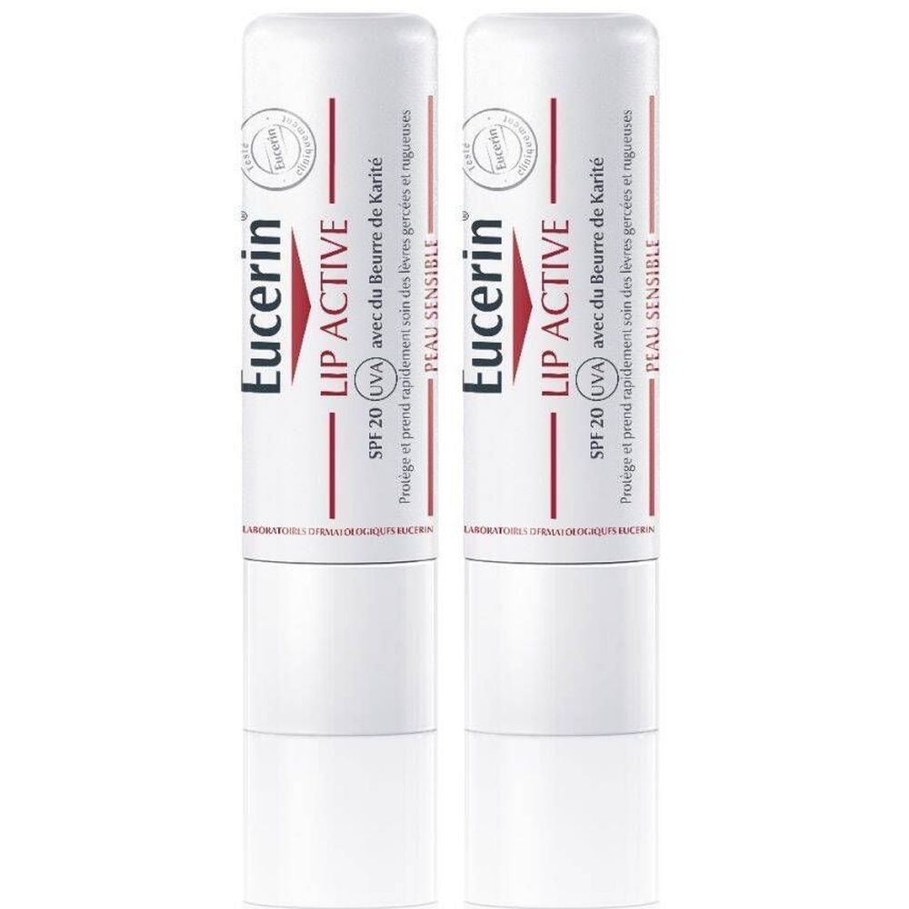 Deux sticks à lèvres blancs. Inscription rouge: Eucerin Lip Active SPF 20. Avec beurre de karité. Peau sensible.