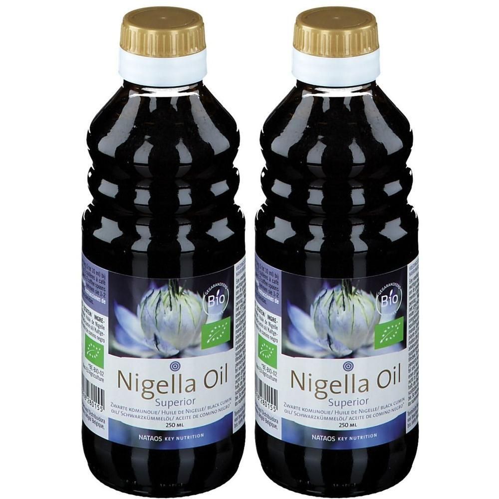 Twee flessen Nigella Oil Superior. Donkere olie in transparante flessen. Gouden dop, witte ring. Bio-keurmerk.