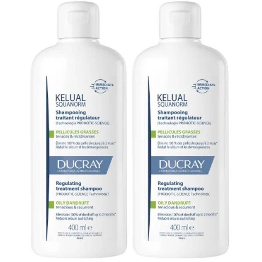 Twee witte shampoo flessen. Opschrift: KELUAL SQUANORM, Shampooing traitant régulateur, Ducray. Voor vette roos.