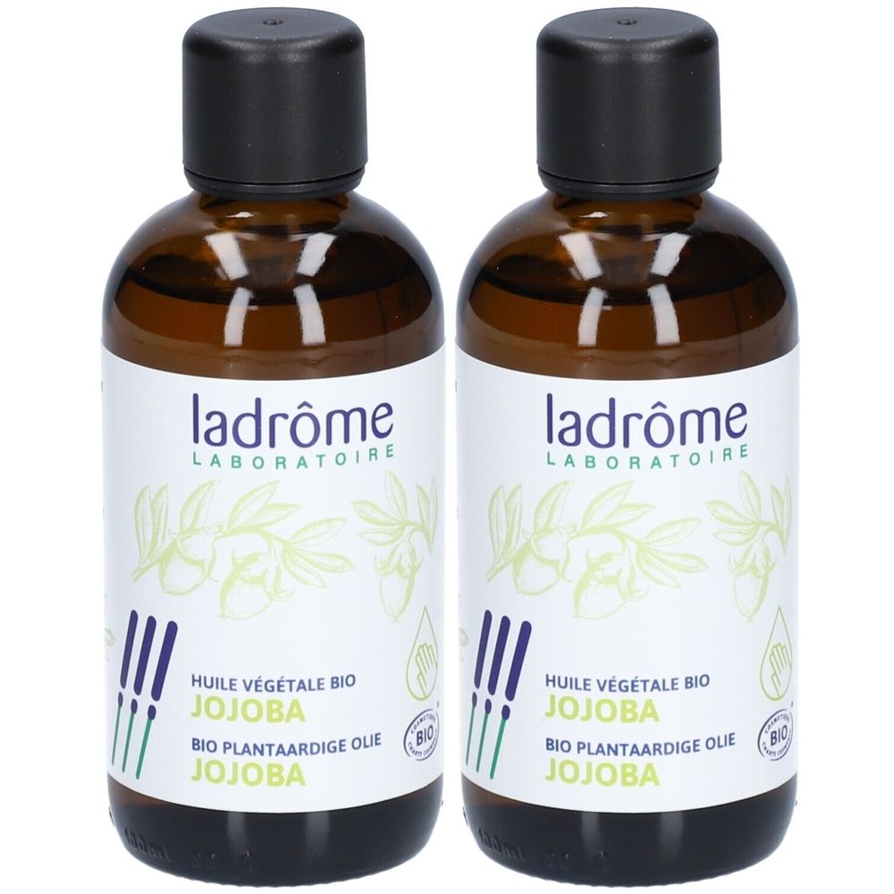 Twee bruine glazen flessen met zwarte dop. Etiket met "ladrôme LABORATOIRE" en "HUILE VÉGÉTALE BIO JOJOBA".